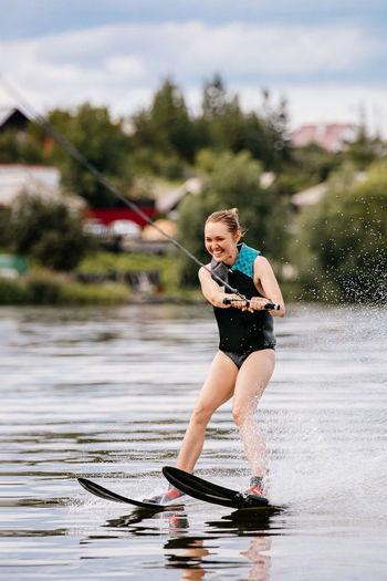 Full length of woman holding umbrella in lake