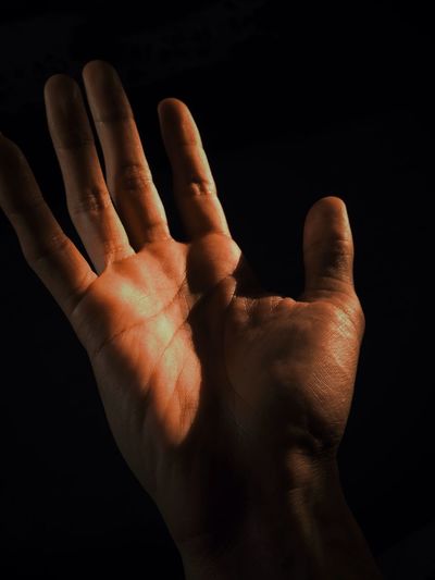 Close-up of hands against black background