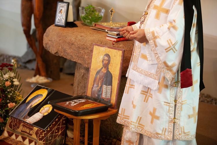 Midsection of priest with religious equipment