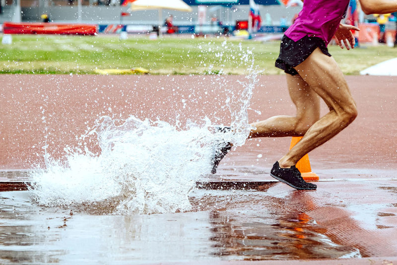 Steeplechase race legs male runner splashing water