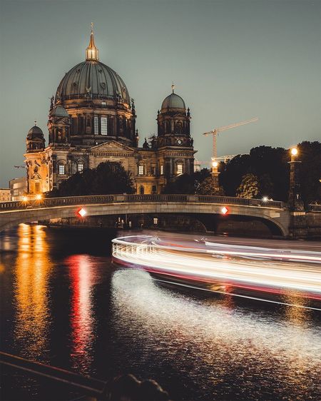 Light trails on spree river by bode museum against sky at night