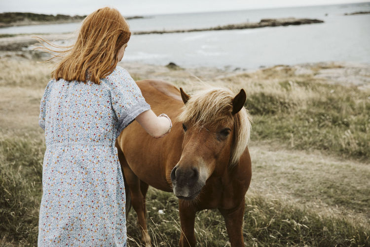 Girl with horse at seaside
