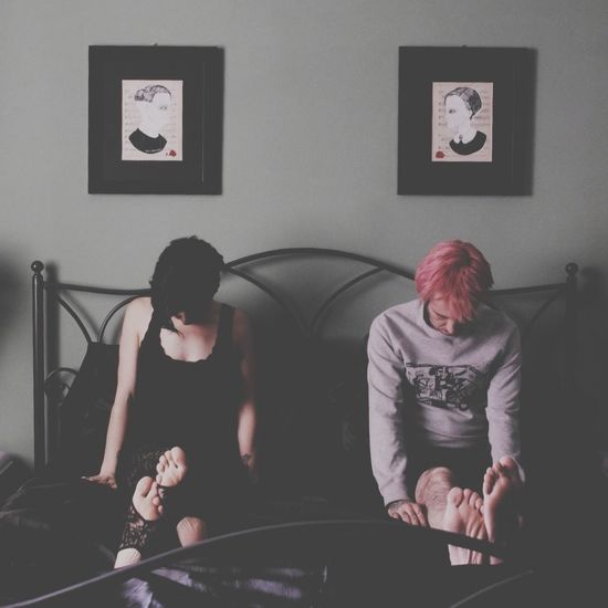 Displeased couple sitting in a bedroom