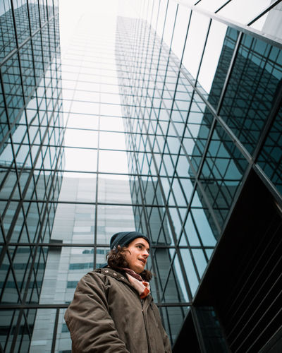 Low angle view of man against skyscraper in city