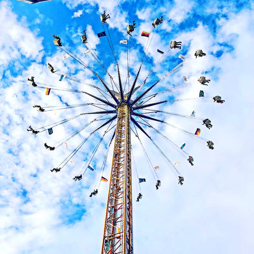 Low angle view of chain swing ride against sky