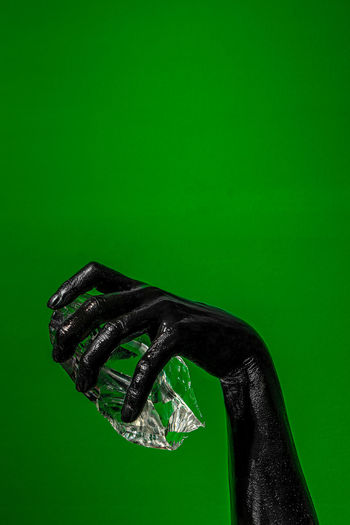 Close-up of human hand against green background