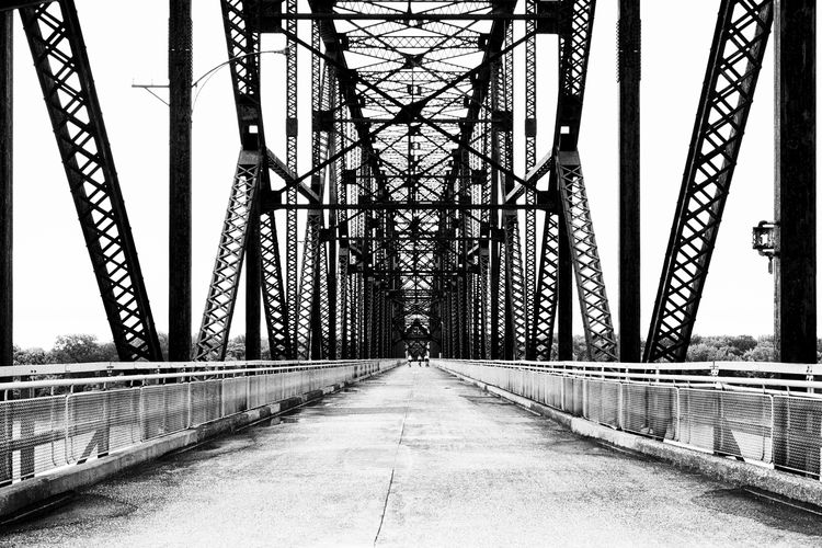 Bridge over road in city against sky