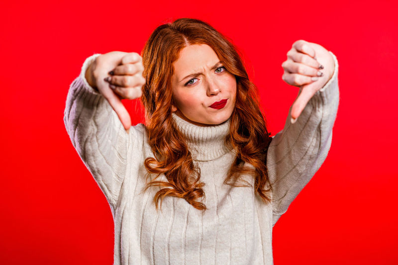 Portrait of a young woman against red background