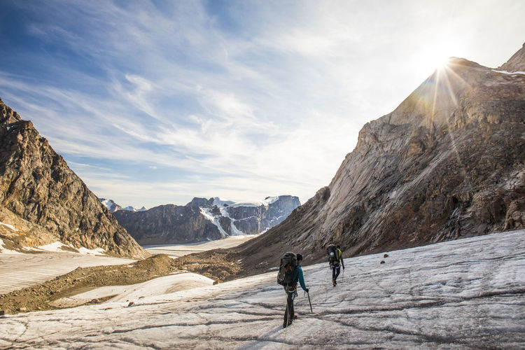 Roped mountaineering team crosses glacier in a mountain landscape.
