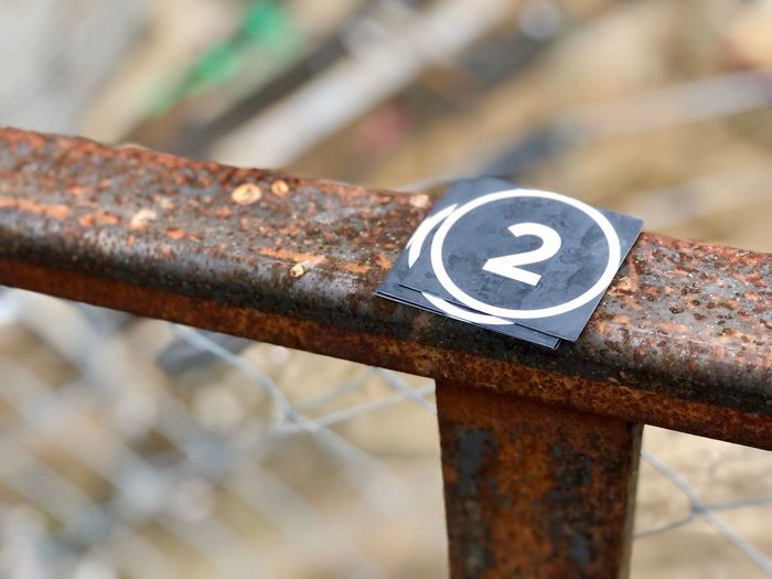 Close-up of number on rusty railing