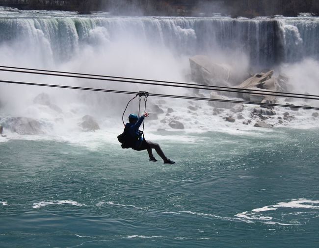 Man zip lining over river