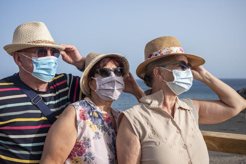 Senior friends wearing mask against sea