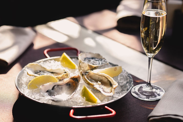 Plate with oysters, lemon and ice and a glass of champagne