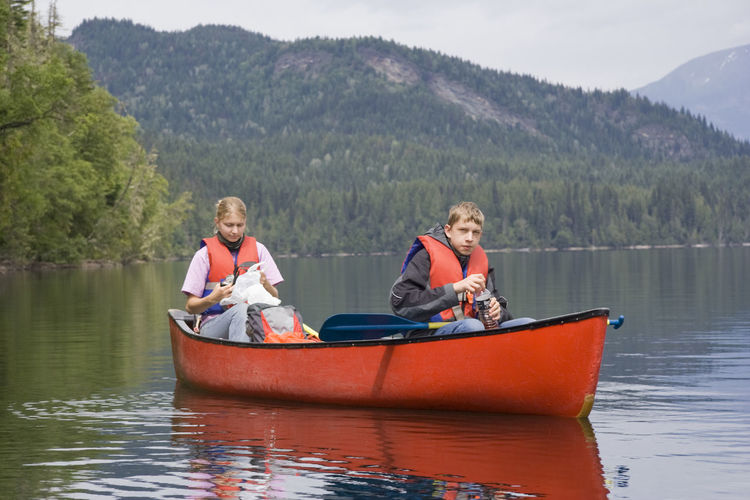 Siblings canoeing on clearwater lake at wells gray provincial park