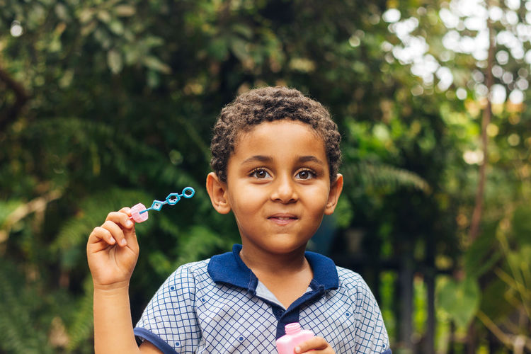 Portrait of smiling boy holding bubble wand