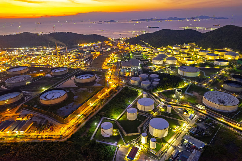 Aerial view oil and gas petrochemical industrial, refinery factory oil storage tank at night.