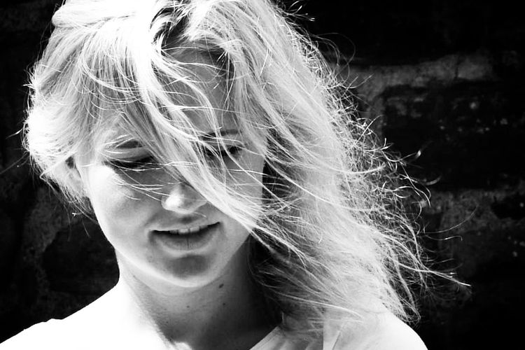 Close-up of young woman with messy hair in sunny day
