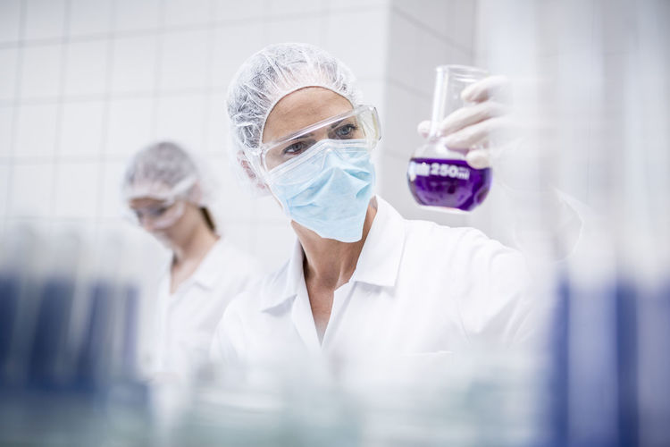 Scientist in lab examining liquid
