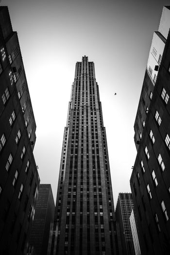 Low angle view of 30 rockefeller plaza and buildings against clear sky