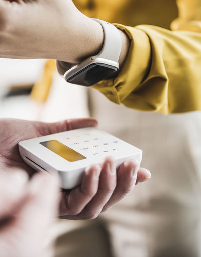 Young businesswoman paying with smart watch on credit card reader