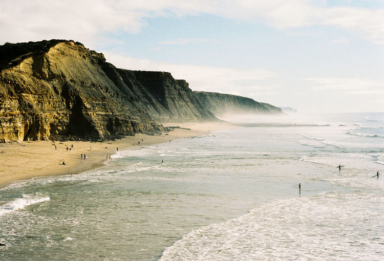 Scenic view of surfer beach in portugal against sky