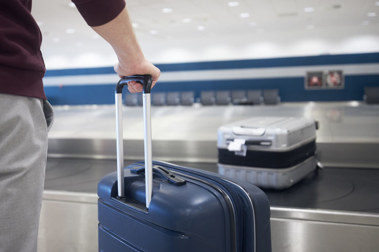 Low section of man holding suitcase