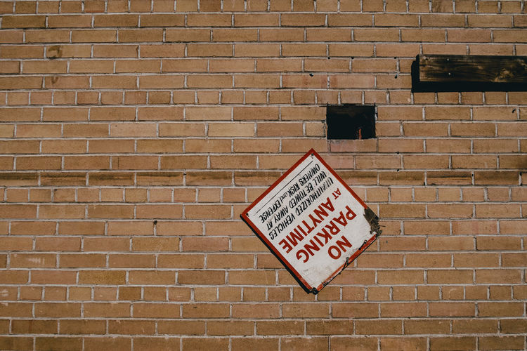 Warning sign on brick wall