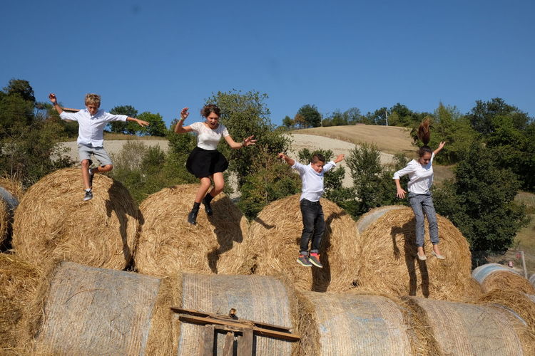 Children jumping on hay bales