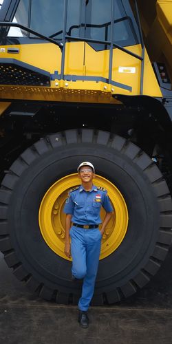 Portrait of man standing against yellow wheel