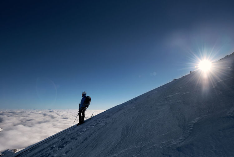 Alpinist standing on snowcapped cervino mountain against sky