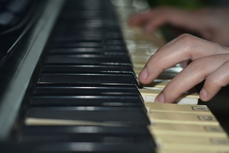 Cropped view of young woman playing keyboard in band