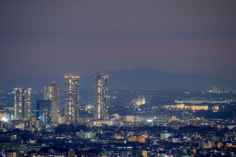 Illuminated cityscape against sky at night