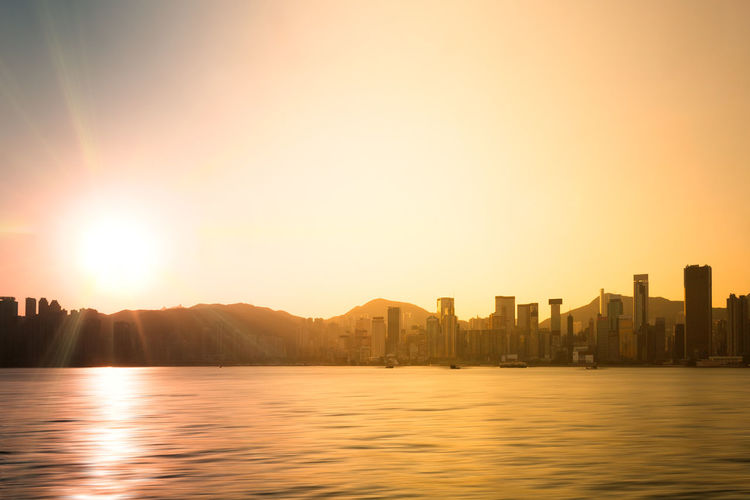 Sunrising behind the silhouetted skyline of hong kong, china