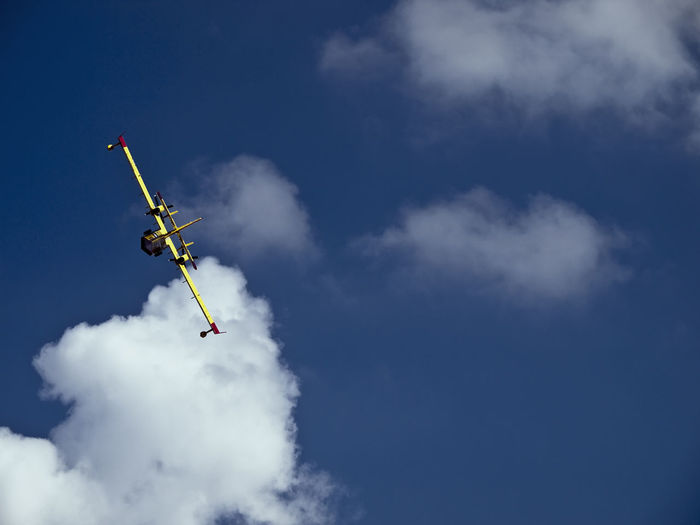 Firefighting aircraft taking off into a blue sky with some cloud