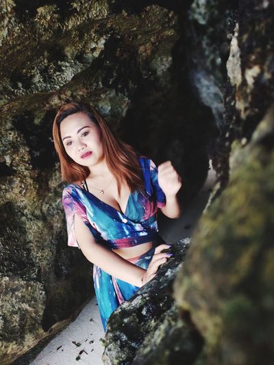 Portrait of a beautiful young woman standing on rock