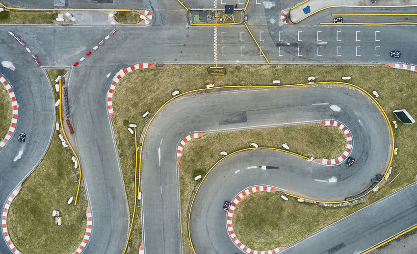 Aerial top view of the go-kart track from the drone. kart racers drive on the open track.