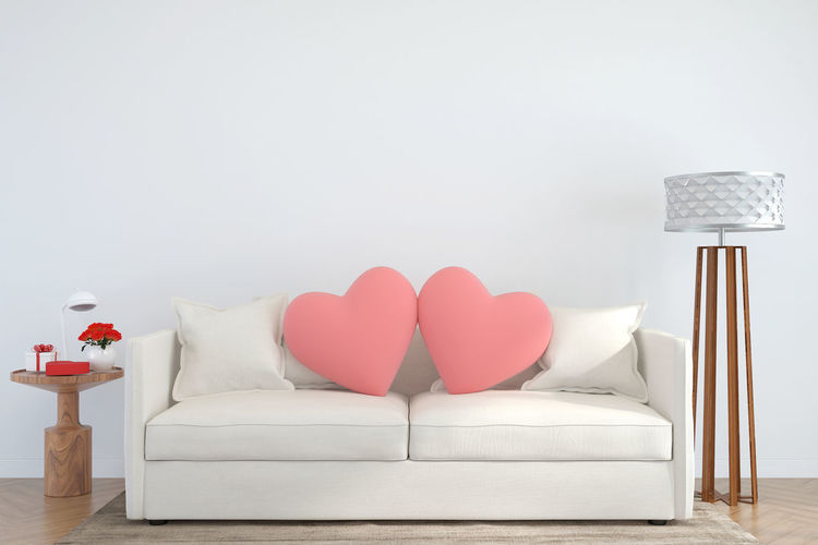 Heart shape on sofa against wall at home