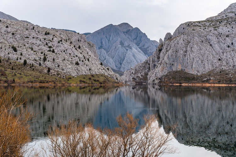 Scenic view of lake and mountains against sky during winter