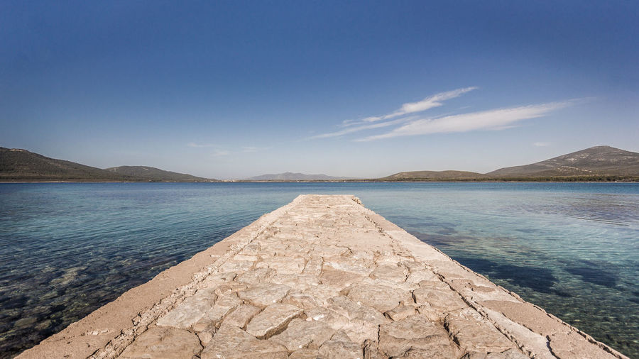 Scenic view of swimming pool by sea against sky