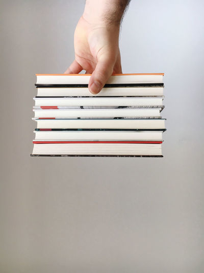 Cropped image of hand holding books