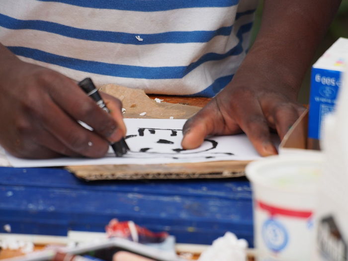 Close-up of man drawing with crayon on paper