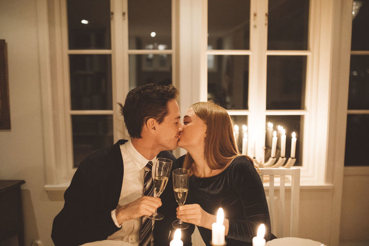 Kissing couple holding champagne flutes
