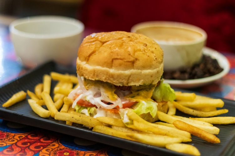 Close-up of burger and fries in plate on table