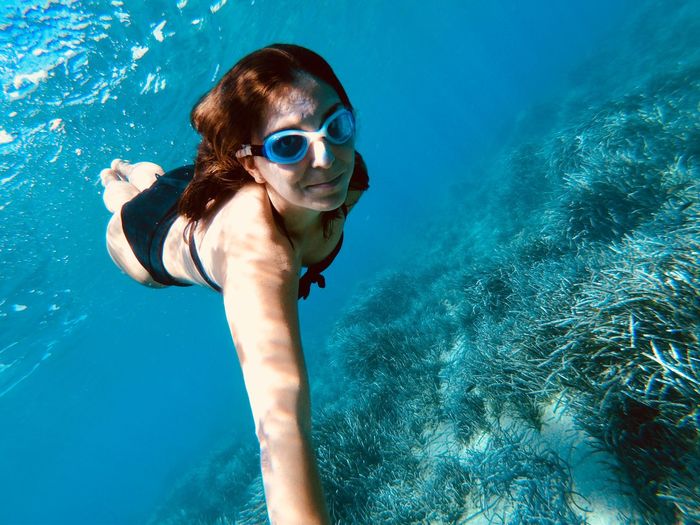 Full length of young woman swimming undersea