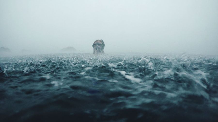 Person swimming in rough sea