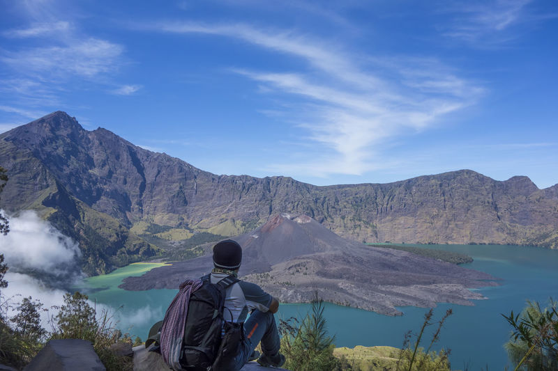 Unidentified man sits and watch a dormant volcanic crater of mount rinjani in lombok indonesia.