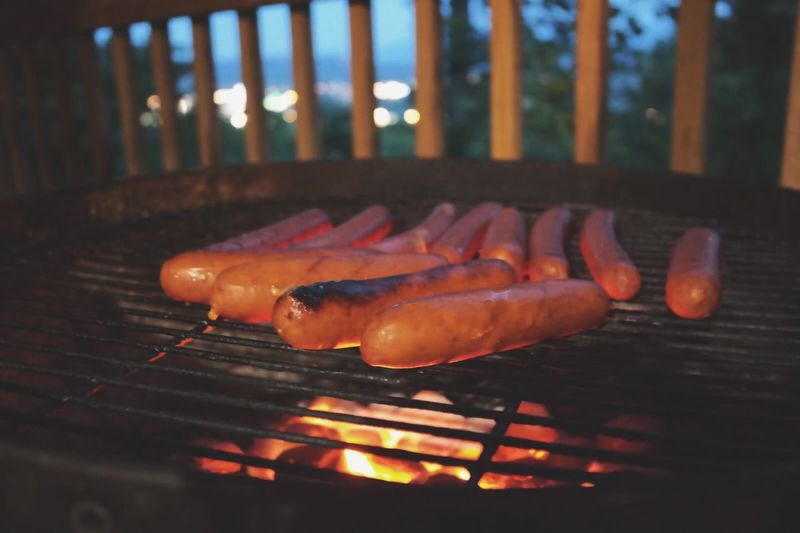Hot dogs roasting on grill outdoors