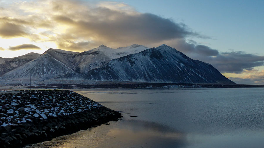 Sun behind snowcapped mountains