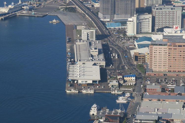 High angle view of buildings by sea in city
