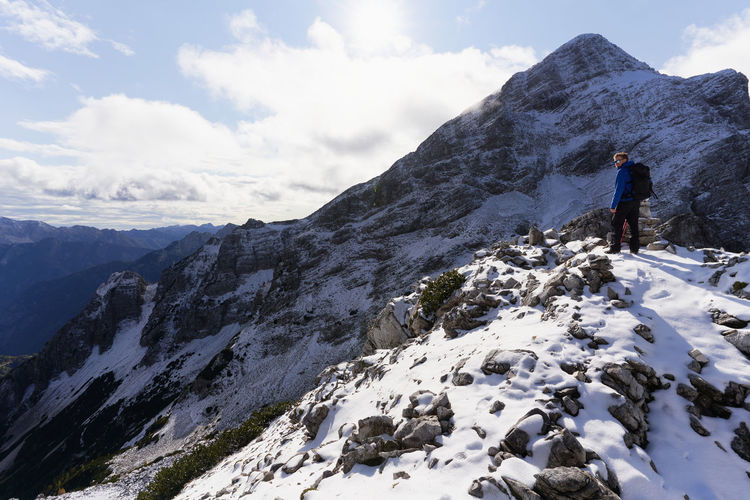 Rear view of people hiking on snowcapped mountain in triglav national park in slovenia